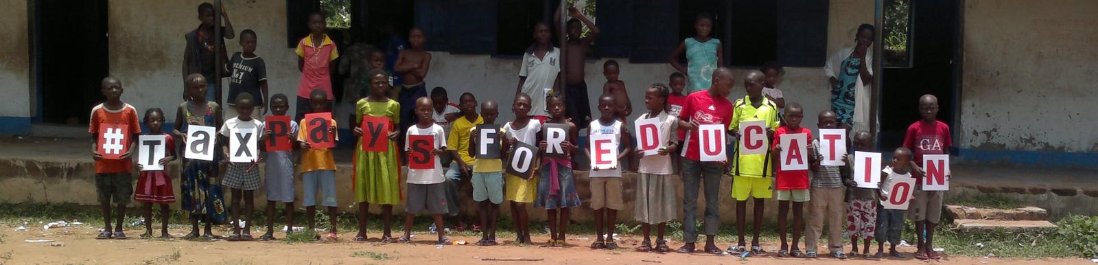 Pupils at the Activista Free Holiday Coaching Lesson in Tionsha community in Benue State Nigeria taking action as part of the Tax Power Campaign 